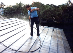 Power washing stained roof shingles.